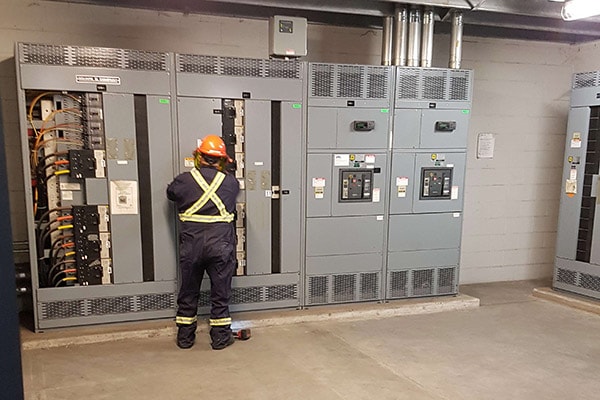 Electrical technician working on industrial switchgear
